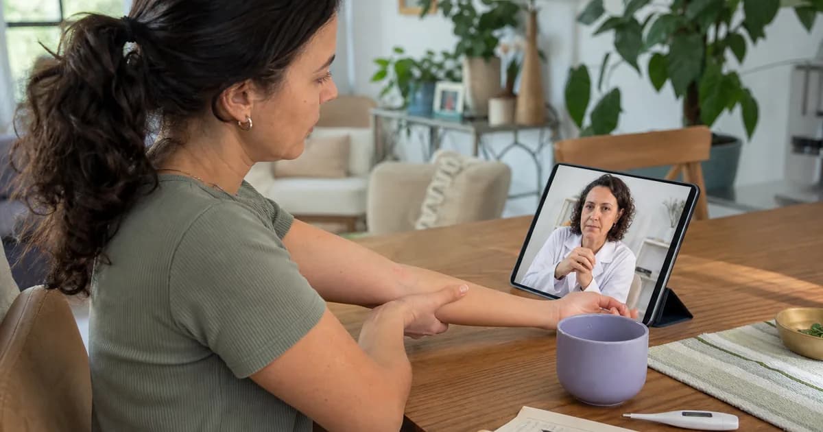 Paciente mostra o antebraço à médica durante teleconsulta por tablet